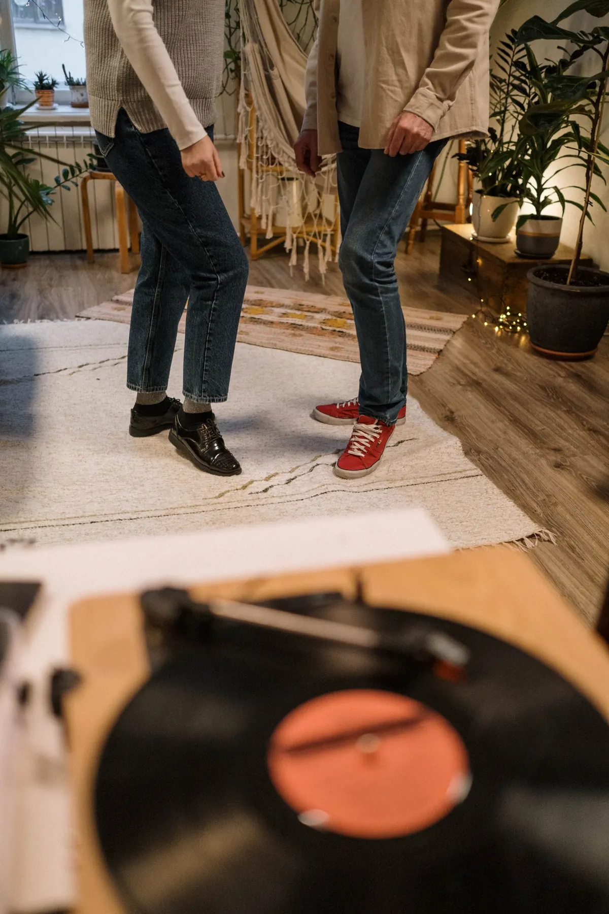 Two pairs of feet dancing beside a spinning record.
