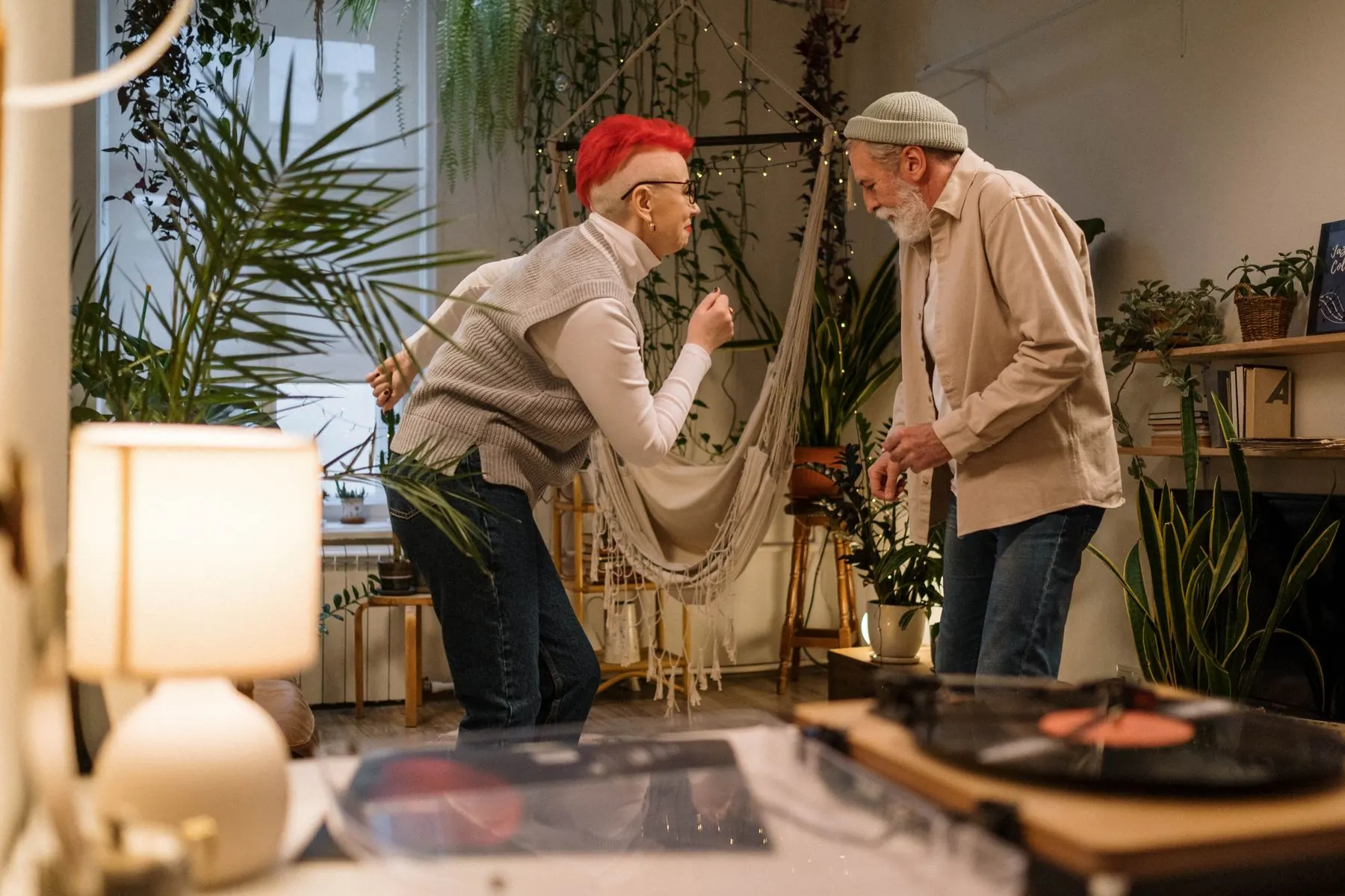 A couple dances together, reflected in a living room window.
