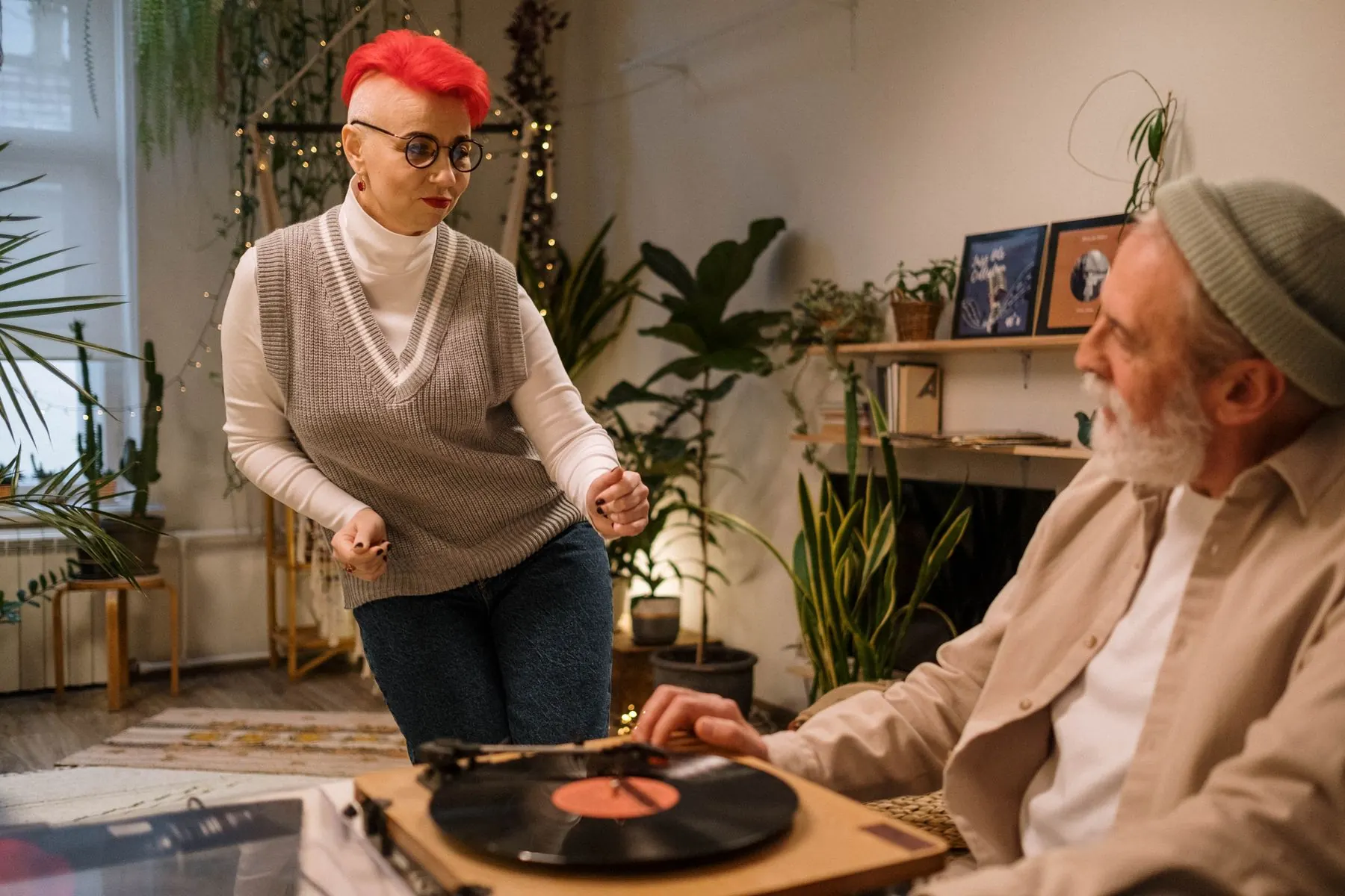 A woman dances while her partner chooses a record.